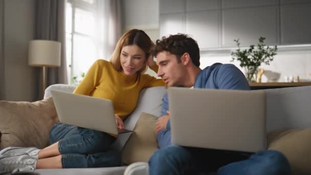 Gülen Çift Kanepe Kapanışında Dizüstü Bilgisayarı Tartışıyor Evdeki Bilgisayarlarda Çalışan — Stok video