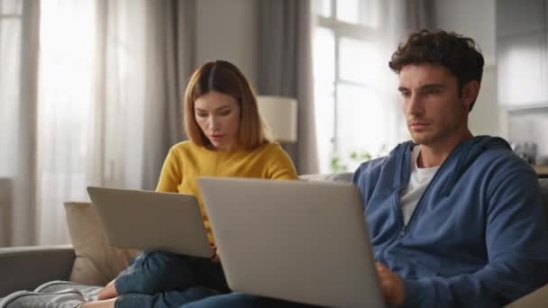 Fokuserede Ægtefæller Sms Bærbare Computere Sidder Sofa Sammen Closeup Alvorlig – Stock-video