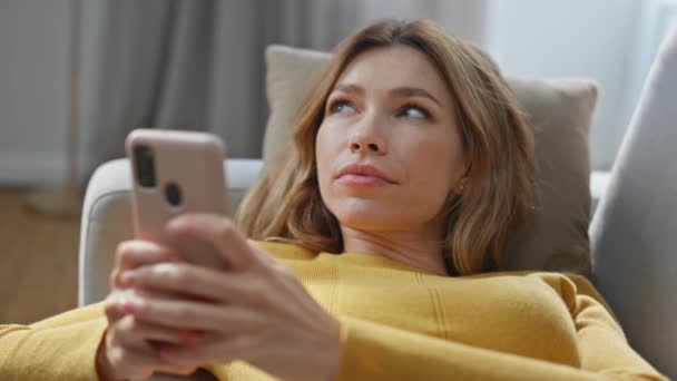 Pensando Mujer Creando Sms Teléfono Inteligente Sofá Relajante Primer Plano — Vídeos de Stock