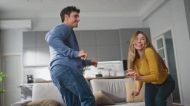 Kaygısız eşler oturma odasında yakınlaşarak oynaşıyorlar. Neşeli bir aile gri renkli dairelere gülerek eğleniyor. Mutlu gülümseyen aşıklar hafta sonu evde dans ediyor. Mutluluk kavramı