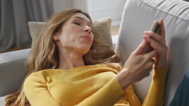 Fröhliche Frau Die Ihr Smartphone Nahaufnahme Auf Dem Heimischen Sofa — Stockvideo