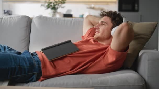 Homem Feliz Ouvindo Música Deitando Sofá Sala Estar Close Cara — Vídeo de Stock