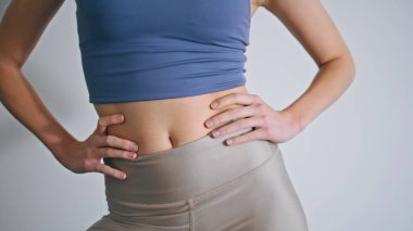 Beyaz Duvar 'da kadın figürlü antrenman vücudu. Spor salonunda el ele tutuşup egzersiz yapan isimsiz atletik kız. Evde tanınmayan bir sabah sporu. Spor rutin konsepti