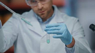 Laboratuvarda pipet doldurma tüpü kullanan odaklanmış bir araştırmacı. Klinikteki tıbbi hazırlıkları inceleyen profesyonel bilim adamı. Laboratuvarda çalışan güvenlik gözlüklü ciddi bir mikrobiyolog..