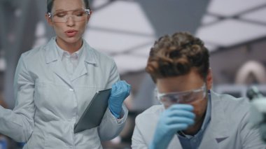 Üzücü bilim adamı, biyokimya laboratuvarında meslektaşıyla çalışırken araştırma başarısızlığını hayal kırıklığına uğrattı. Kadın araştırmacı üzgün adama sempati duyuyor. İki kimyager deneyden memnun kalmadılar..