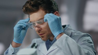 Güvenlik gözlüğü takan bilim adamları gelişmiş laboratuarlardaki ilaçları yakından inceliyorlar. Gözlük takan ciddi bir araştırmacı. Kendine güvenen genç biyologlar biyoteknoloji laboratuvarında çalışmaya başlarlar..