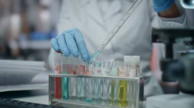 Laboratuvar çalışanı deney tüpünü bilimsel araştırmalar yapan deneysel ilaçlarla dolduruyor. İlaç maddesine bakan ciddi bir kadın bilim adamı. Aşıyla çalışan gözlüklü kadın biyoteknoloji uzmanı..