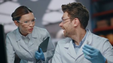 Mutlu bilimadamları Coronavirus 'tan alınan ilaçları icat etti. Heyecanlı araştırmacılar laboratuarda tıbbi başarıyı kutluyorlar. Gülümseyen laboratuar teknisyenleri aşıyı keşfettikleri için çok mutlu..