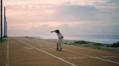Profesyonel kaykaycı günbatımı okyanus arka planında numara yapıyor. Aktif kaykaycı çocuk yaz seti sürüşünün tadını çıkarıyor. Şık hipster akşam koşu bandında kaykay dengeliyor. 