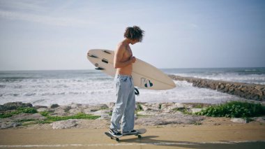 Güzel okyanus kıyısında sörf tahtasıyla sörf yapan rahat kaykaycı. Yazın sahil yolunda yarı çıplak sörf yapan kaykaycı dövmesi yaptırdım. Yavaş çekimde sörf yapan bir sörfçü..