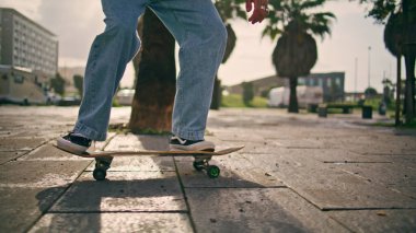 Yakın plan havalı kaykaycı güneşli bir günde kaykay numarası yapıyor. Tanımlanamayan genç kaykaycı, ağır çekimde dengede duruyor. Bilinmeyen trend adamı yaz caddesinde paten antrenmanı yapıyor..