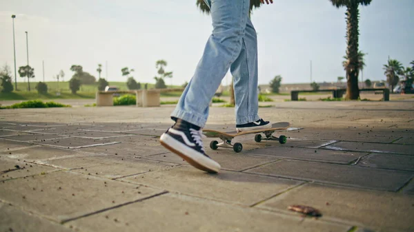 Kaykaycı bacakları yaz günü kaykay sürerken asfalttan itiyor. Bilinmeyen modern kaykaycı şehir caddesinde kaykay eğitimi alıyor. Modayı takip eden genç hippi kaykay yavaş çekimde dengede duruyor. Etkin hobi.