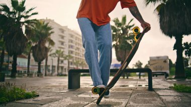 Sokak yaz akşamında kaykayla aşırı çocuk antrenman numarası. Bilinmeyen kaykaycı bacakları kaykay tekerleğinde dengede duruyor. Aktif adam açık havada spor hobisini seviyor. Spor yaşam tarzı.