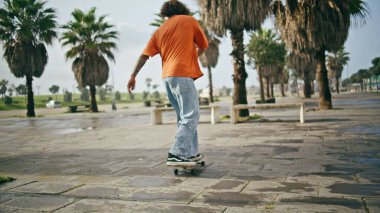 Park kaldırımında uzun panoda paten kayan genç trend. Şehir sokağında kaykayla dengede duran şık bir hippi. Aktif patenci çocuk ağır çekimde yazın aşırı hobisinin tadını çıkarıyor. Spor eğlence konsepti.