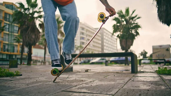 Kentin kaldırımlarında tanınmaz haldeki kaykaycı adam numaralarını yapıyor. Kaykay tekerleğinde dengede duran etkin çocuk ayakları bulutlu gökyüzünde güvertede zıplıyor. Kaykaycı ağır çekimde sörf yapıyor..