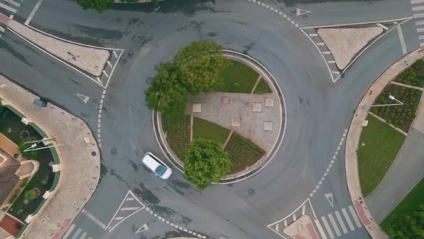 小さなヨーロッパの町の緑の都市ラウンドアウトトトップビュー 円形の動きでアスファルト横断に乗っている車 現代の輸送車両インフラストラクチャーシュート 都市道路サークルを横断する自動車 — ストック動画
