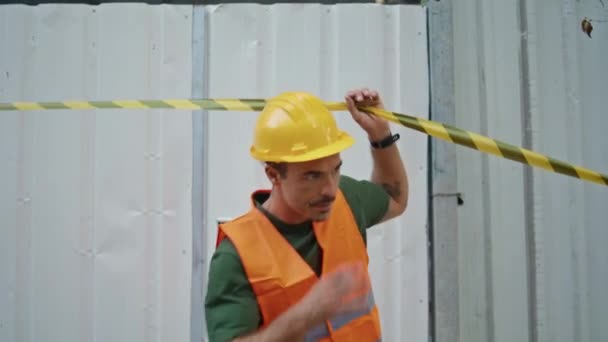 Byggaren Passerar Varningstejp Byggarbetsplatsen Närbild Självsäker Man Arbetare Tar Hårdhatt — Stockvideo