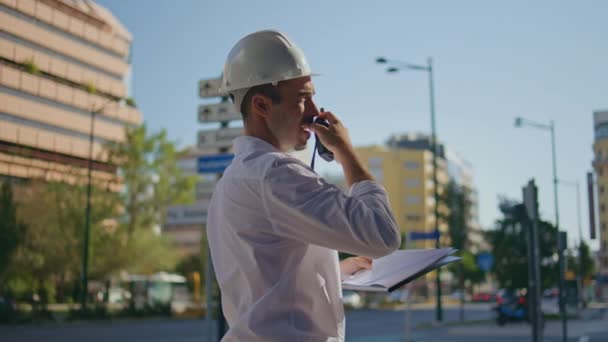 Hardhat Építész Beszél Utasításokat Távolról Nyári Város Közelkép Komoly Profi — Stock videók