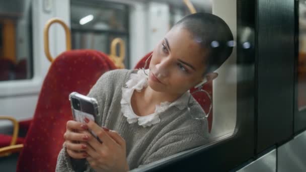 孤独的女人乘火车看智能手机屏幕关闭 悲伤的短发乘客在耳机里听音乐 打开手机应用程序 不快乐的女孩游客厌倦了一个人坐火车旅行 — 图库视频影像