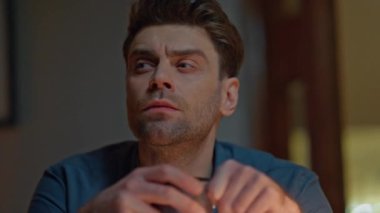 Fincanı tutan düşünceli adam gece evinde yakın plan düşünüyor. Üzgün, dalgın bir adam, elinde kupa taşırken akşam vakti kafa yorarken sorunlar yaşıyor. Kaşlarını çatmış esmer, derin düşünceler içinde yalnız başına mesafeyi arıyor.