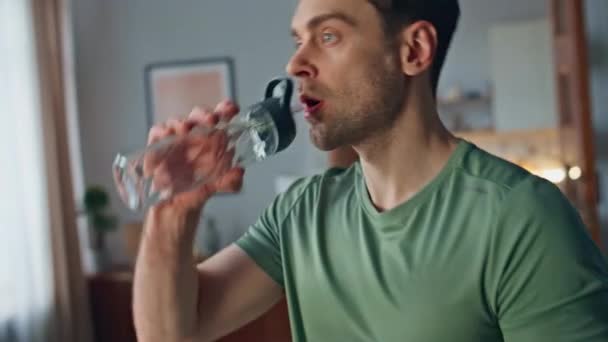 Gesunder Mann Trinkt Wasser Aus Glasflasche Wohnzimmer Der Wohnung Aus — Stockvideo