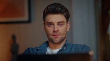 Rahat adam gece iş yerinde dizüstü bilgisayarı yakından izliyor. Tatmin olmuş esmer adam kollarını uzatıyor ve akşam lambasının düz ışığında başının arkasına koyuyor. Yurt içi serbest çalışan bilgisayar ekranı e- postalarını tek başına okuyor.