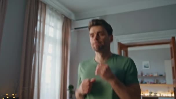 촬영에서 운동에 활기찬 아파트에서 티셔츠 강도에 적극적인 잘생긴 열정적 운동선수 — 비디오