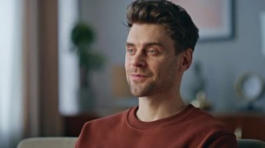 Ev koltuğunda dizüstü bilgisayarda klavye yazan gülümseyen adam. İnternette arkadaşlarıyla sohbet eden yakışıklı bir adam bilgisayardaki koltuğa oturup mesaj yazıyor. Mesafe çalışmasından memnun olan mutlu çevrimiçi yönetici.