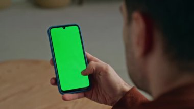 Dolaba yakın çekimde kullanıcı kromakey akıllı telefonu. İş adamı ofisinde şablon cihazını tutuyor. Tanımlanamayan işadamı sıcak iş yerinde yeşil ekran cep telefonu ağı kullanıyor.
