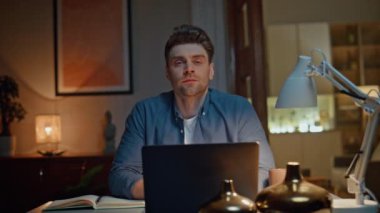 Mutlu serbest çalışan, geç saatte iş yerinde çekilmiş bir fotoğraf makinesi. Pozitif öğrenci, akşam evinde dinleniyor. Güler yüzlü adam gece iç mekanda tek başına poz veriyor. Uzak çalışma konsepti