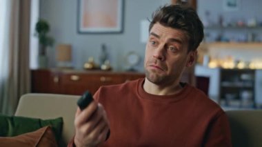 Portreli adam rahat koltukta tek başına televizyon seyrediyor. İlginç bir kanal seçen yakışıklı adam uzaktan kumanda düğmesine basıyor. Cidden gevşemiş hipster TV haberleri seyrediyor. Kanepeye yakın oturuyor.