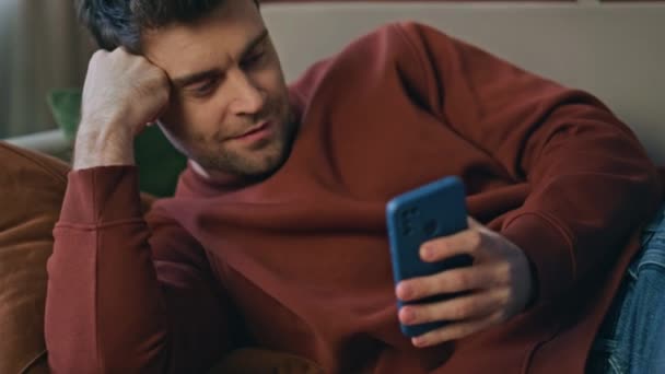 Bored Man Browsing Mobiltelefon App Liggende Komfortabel Sofa Nærbillede Smilende – Stock-video