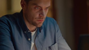 Karanlık ev çekimlerinde klavye yazan adam elleri. Modern apartmandaki masada dizüstü bilgisayarla mesajlaşan yakışıklı adam. Bilgisayarı kullanarak internet üzerinde gezinen düşünceli serbest yazar.