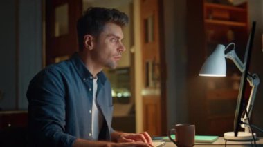 Klavyeyle mesajlaşan odaklanmış adam gece evde tek başına çalışıyor. Dikkatli bir bilgisayar ekranının karanlık iş yerinde son teslim tarihi var. Akşam saatlerinde ciddi yönetici daktilo hazırlama projesi