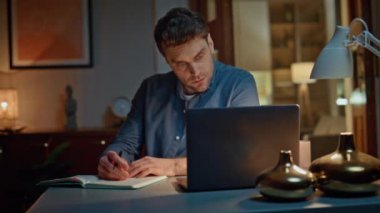 Çevrimiçi öğrenci, gece evde bilgisayarlı ekranı yakından inceliyor. Ciddi bir adam, bilgisayarla birlikte kitap masasına oturmuş not alıyor. Odaklanmış Serbest Çalışan İnternet kursuna gidiyor. Video dersi izliyor.