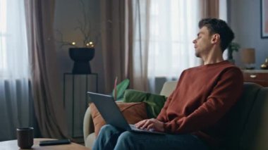 Endişeli yazar oturma odasındaki kanepede dizüstü bilgisayar yazıyor. Ciddi bir adam evinde kanepede otururken kendini yorgun hissediyor. Uzaktan kumandalı çalışanın iş sorunlarını internetle çözmesi konusunda endişelenmesi.