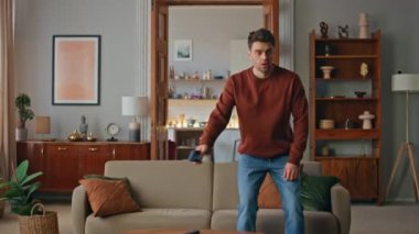 Yorgun adam rahat bir kanepede oturur. Yorgun genç bir adam akıllı telefon ekranına bakıyor sıkı çalışmadan sonra kanepede dinleniyor. Cep telefonu olan, yorgun ve yakışıklı bir erkek oturma odasında kendini tükenmiş hissediyor..