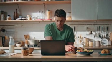 Çay fincanı tutan düşünceli işçi mutfak tezgahına yakından bakıyor. Ciddi düşünceli adam kahvaltıda çalışırken iş meseleleri düşünüyor. Esmer adam dizüstü bilgisayarı izliyor, kahvesini yudumluyor.