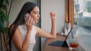 Çevrimiçi çalışan restoran masasında akıllı telefondan konuşan dizüstü bilgisayar ekranı. Lüks Koreli iş kadını cep telefonuyla sipariş verip bilgisayardan mal seçiyor. Freelancer 'dan müşteriye.