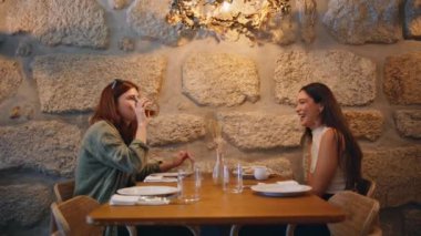 Lgbt çifti kafe ile çıkıyor ve rahat atmosferin tadını çıkarıyor. Modern kafeteryada içki içmekten bahseden iki kadın. Çift lezbiyen kızlar birlikte gülerek dostça sohbet ederler. Dedikodu yapan arkadaşlar..