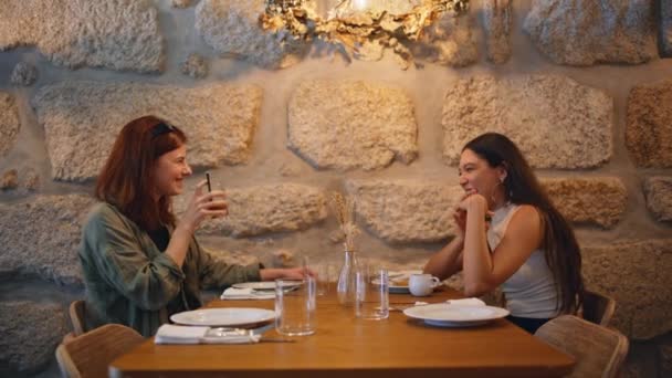 Par Compañeras Riendo Cafetería Moderna Bebiendo Bebidas Bajo Luz Lámpara — Vídeo de stock