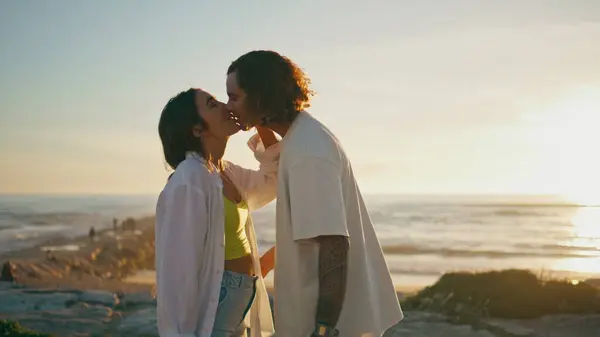 大海在日落时亲吻着青少年夫妇 轻柔地拥抱在平静的海滨 快乐的一对 爱两个人在海洋黄昏的自然中度过浪漫的约会 恋爱关系概念 — 图库照片