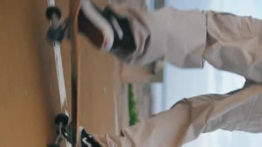 Bulutlu deniz kıyısında dikey olarak kaykay yapan son moda genç adam. Okyanus sahilinde paten kayma pratiği yapan tanınmamış bir sporcu. Yavaş çekimde kaykaycı ayakları uzun panoda hobi olarak çalışıyor..