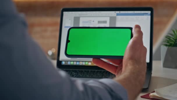 男子触摸彩色关键手机的横向位置在工作场所的特写 无法辨认的家伙盗用了模拟智能手机观看视频 办公室里的男性手指敲击绿色屏幕手机 — 图库视频影像