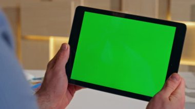 Şirket çalışanı ofisteki yeşil ekran tablet tarama video içeriğini kapatıyor. Tanınmayan işadamı elleri krom anahtar bilgisayarı tutuyor. İş yerinde sosyal medyayı izleyen erkek müdür içeride mola veriyor