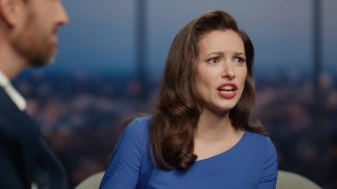 Stüdyoda ünlü konuklarla televizyon programı sunan etkileyici sunucu. Erkek konuşmasına duygusal tepki veren şaşırtıcı kadın sunucu. Güzel spiker ziyaretçi televizyon programını alkışlıyor..