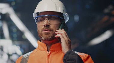 Gülümseyen endüstriyel mühendis cep telefonuyla konuşuyor. Metalurji fabrikasıyla anlaşma yapıyor. Mutlu hırdavat şirketi sahibi akıllı telefondan konuşuyor. Sakallı teknisyen cep telefonuyla konuşuyor.