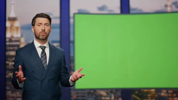 Breaking news reporter talking in front chroma key monitor tv studio close up. Confident newscaster beginning broadcast daily news showing information on green screen. Professional television concept.