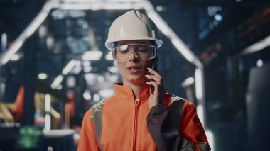 Büyük fabrika deposundan kadın endüstriyel işçiler arıyor. Profesyonel fabrika çalışanı cep telefonu konuşmasında üretim düzenini tartışıyor. Üniformalı kadın fabrika teknisyeni akıllı telefon konuşuyor..
