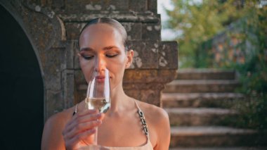 Terk edilmiş güzel bir sarayda beyaz şarap içen zarif bir kadın. Dışarıda duran cam kadehten şampanya içen rahat çekici kız. Şatoda alkolün tadına bakan şık bir kadın..